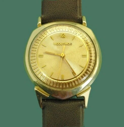 Gold Accutron wristwatch with brown leather band.