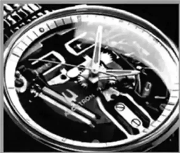 A black and white photo of a watch with tools in it.