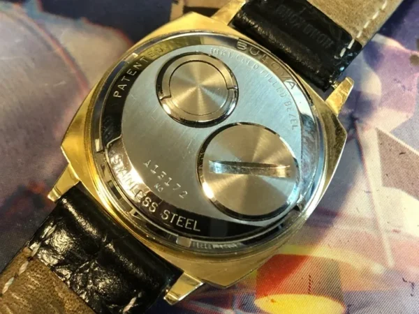 A gold watch with two faces on the side of it.