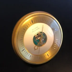 A gold clock with a white face and a black background