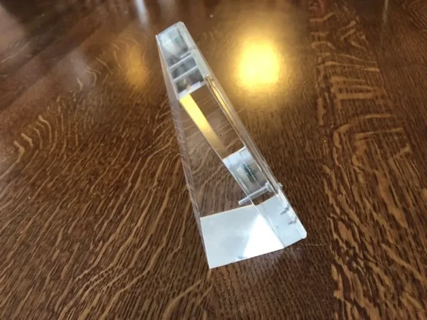 A clear glass object sitting on top of a wooden table.