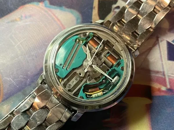 A watch with some parts missing and the back of it