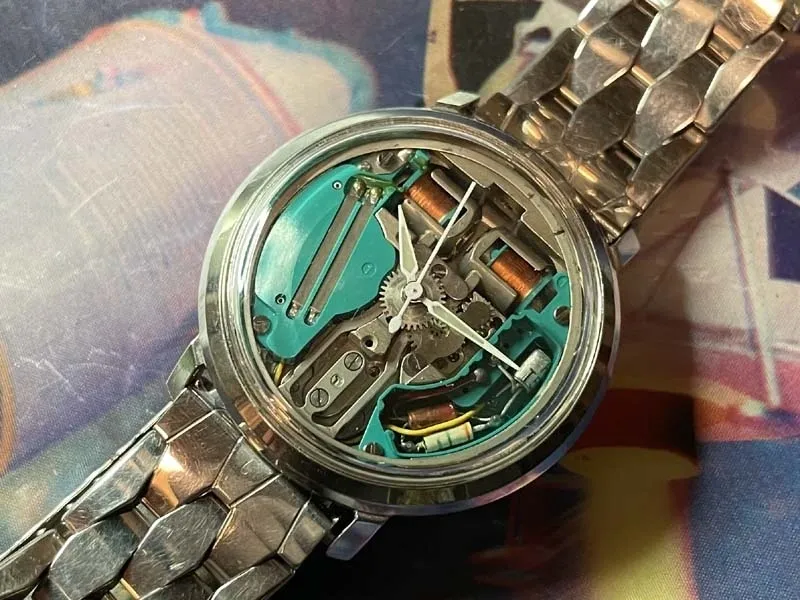 A watch with some parts missing and the back of it