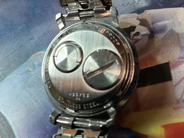 A watch is shown on top of a picture.