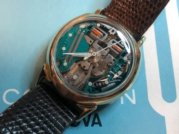 A watch with some parts missing on top of a book.