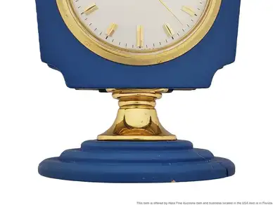 A blue clock with gold trim and roman numerals.