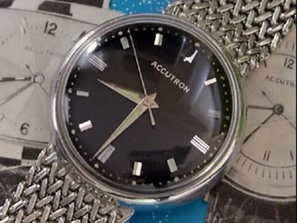 A watch is shown with some money on the side.