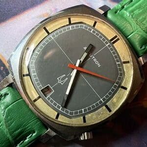 A watch with green leather strap and gold face.