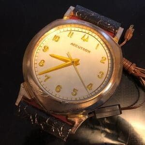 A watch with yellow numbers on it