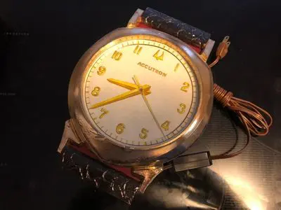 A watch with yellow numbers on it