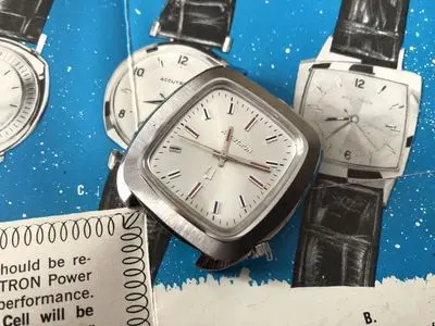 A watch is shown on top of some papers.