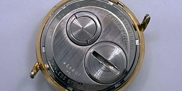 A close up of the back side of an analog watch