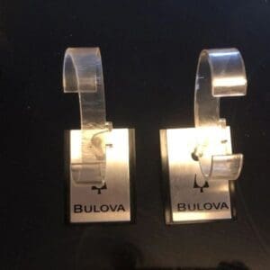 A pair of bulova watch hanging on the wall.