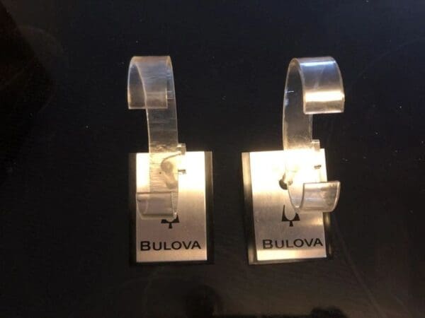 A pair of bulova watch hanging on the wall.