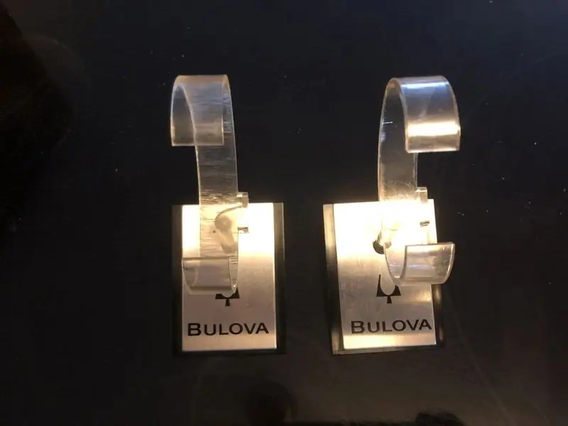 A pair of bulova watch hanging on the wall.