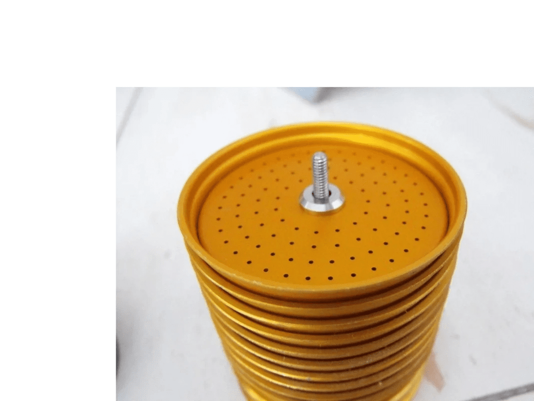 A stack of yellow plates with holes on them.