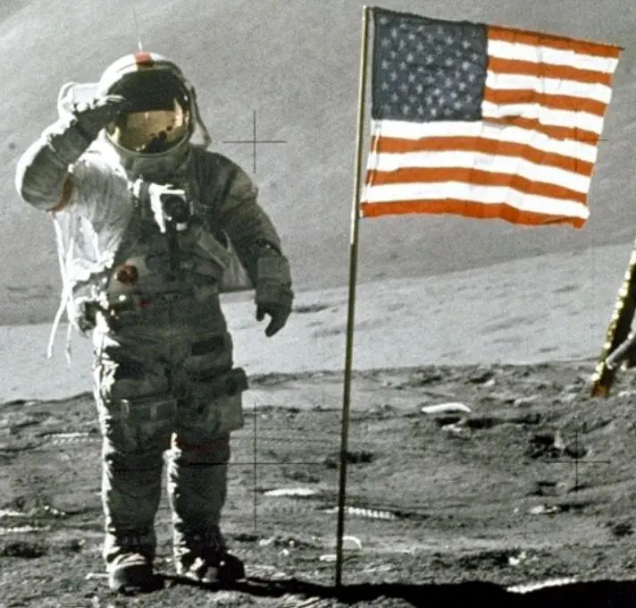 Astronaut saluting US flag on the moon.