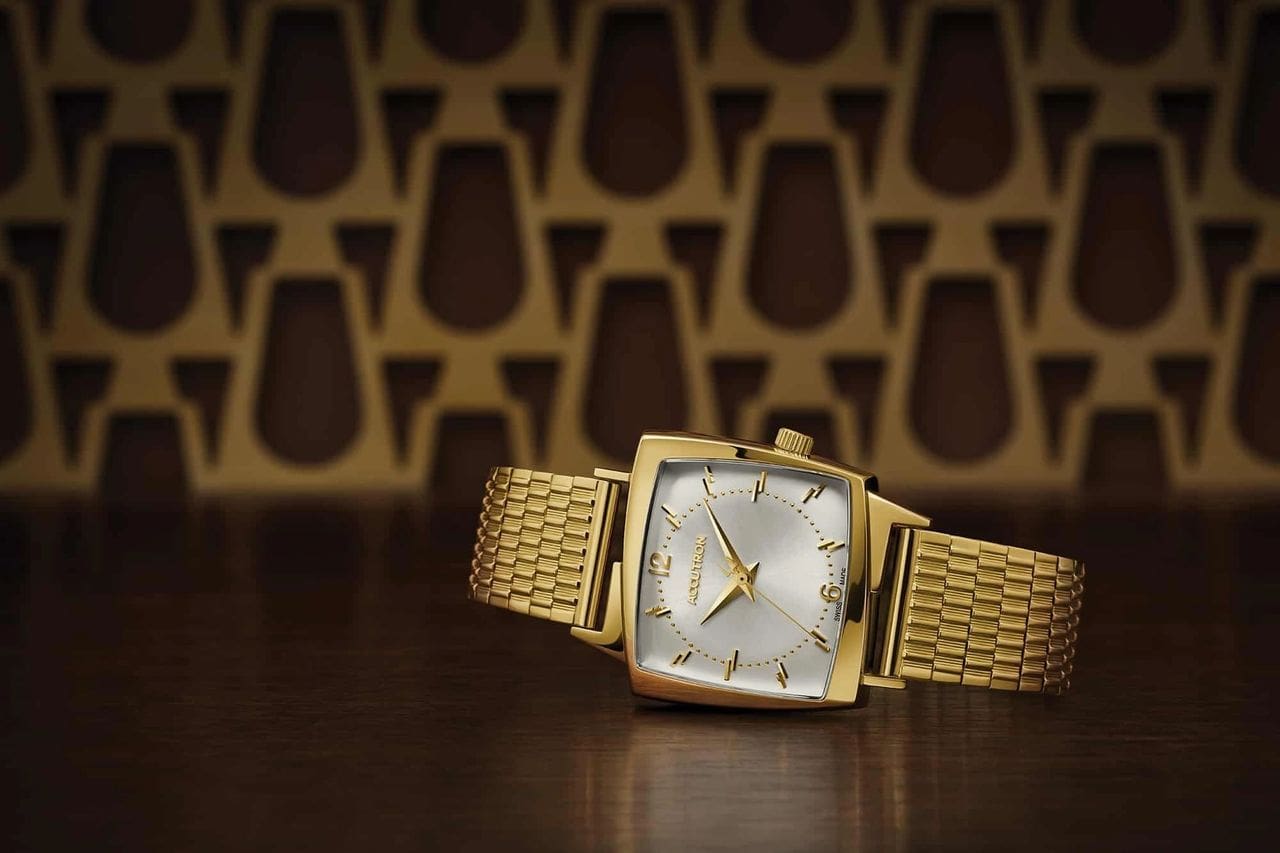 Gold Accutron watch with square face.