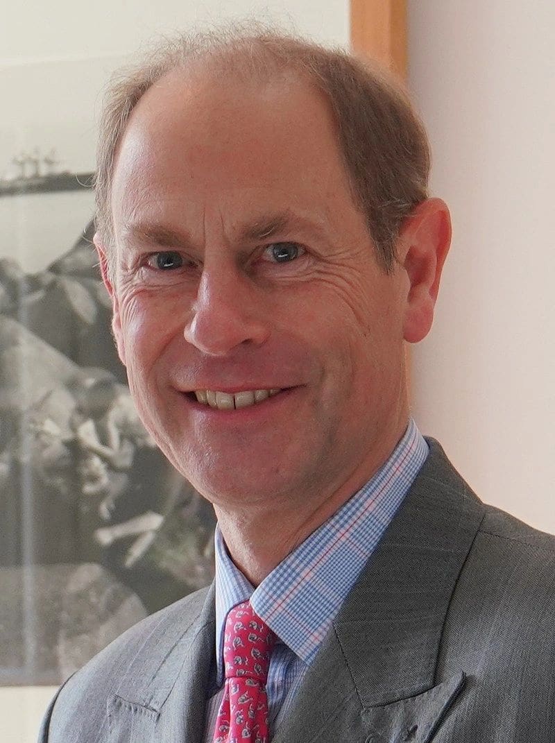 Smiling man in suit with pink tie.