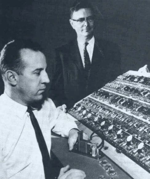 Two men working on a computer circuit board.