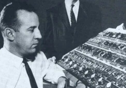 Two men working on a computer circuit board.