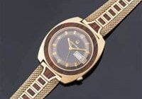 Gold wristwatch with brown wooden band.